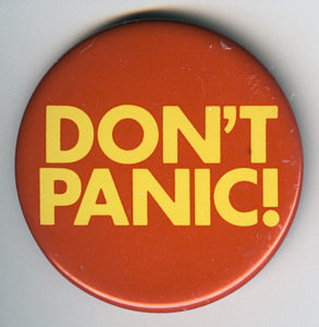 Et badge med teksten “DON’T PANIC!”